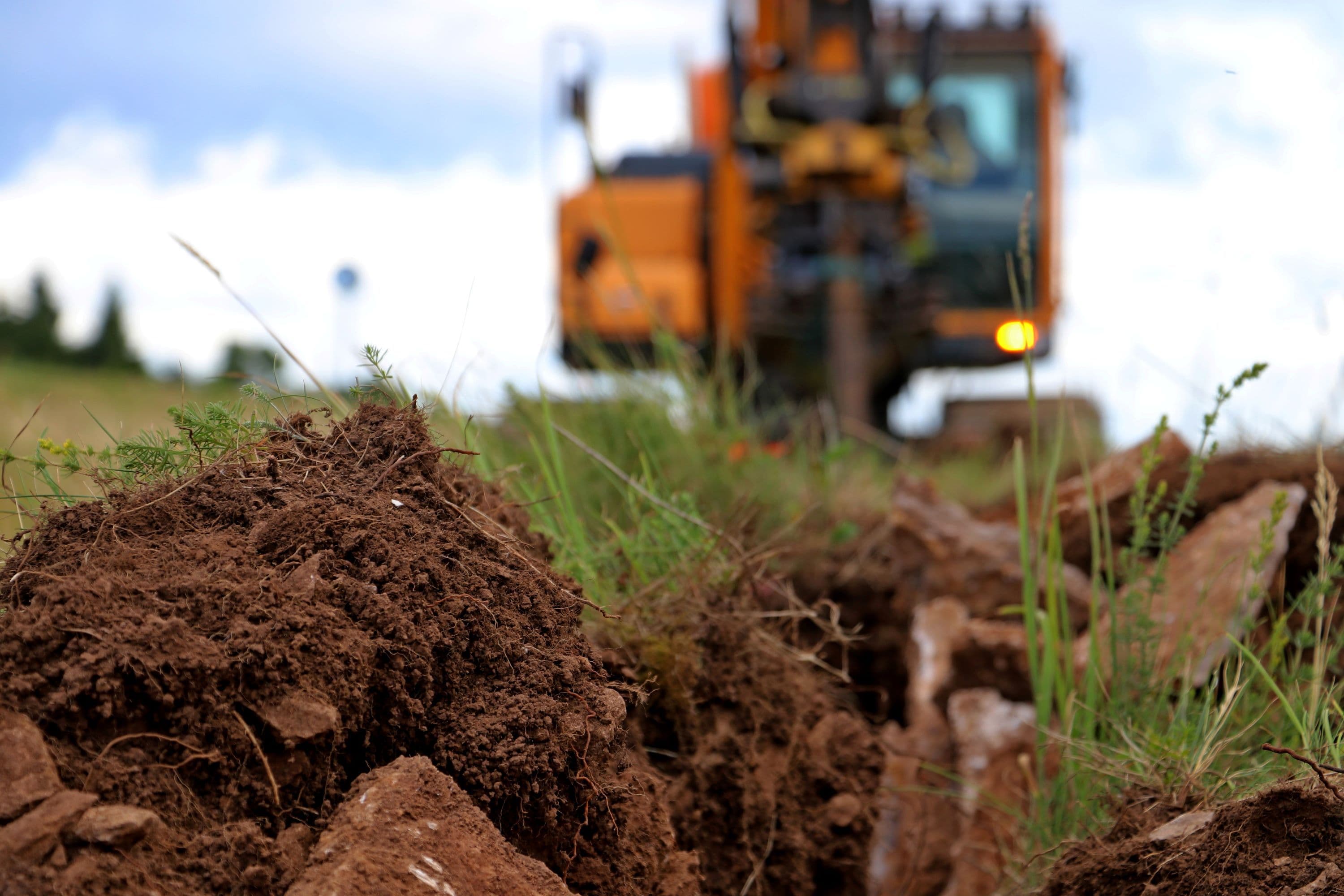 Small excavator digging up grass