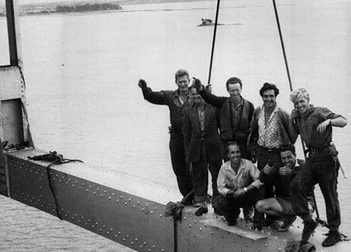 Old black and white photo, group of 6 work men sitting up on bridge construction