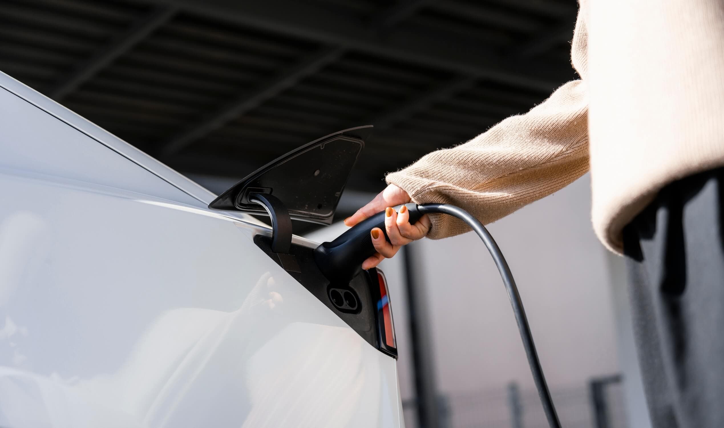 Person plugging in an EV